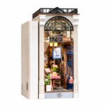 Book Nook Kit Arcade Dating DIY Kit with ornate white arch, warm lamps, flowers, signs, and miniature storefront