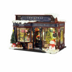 Fantasy Book Nook Kit Christmas Wonderland with snowy storefront, trees, gifts and snowman on white background