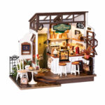 Book Nook Kit Slow Life Café miniature coffee shop with counter, stools, table, plants and warm lighting on white