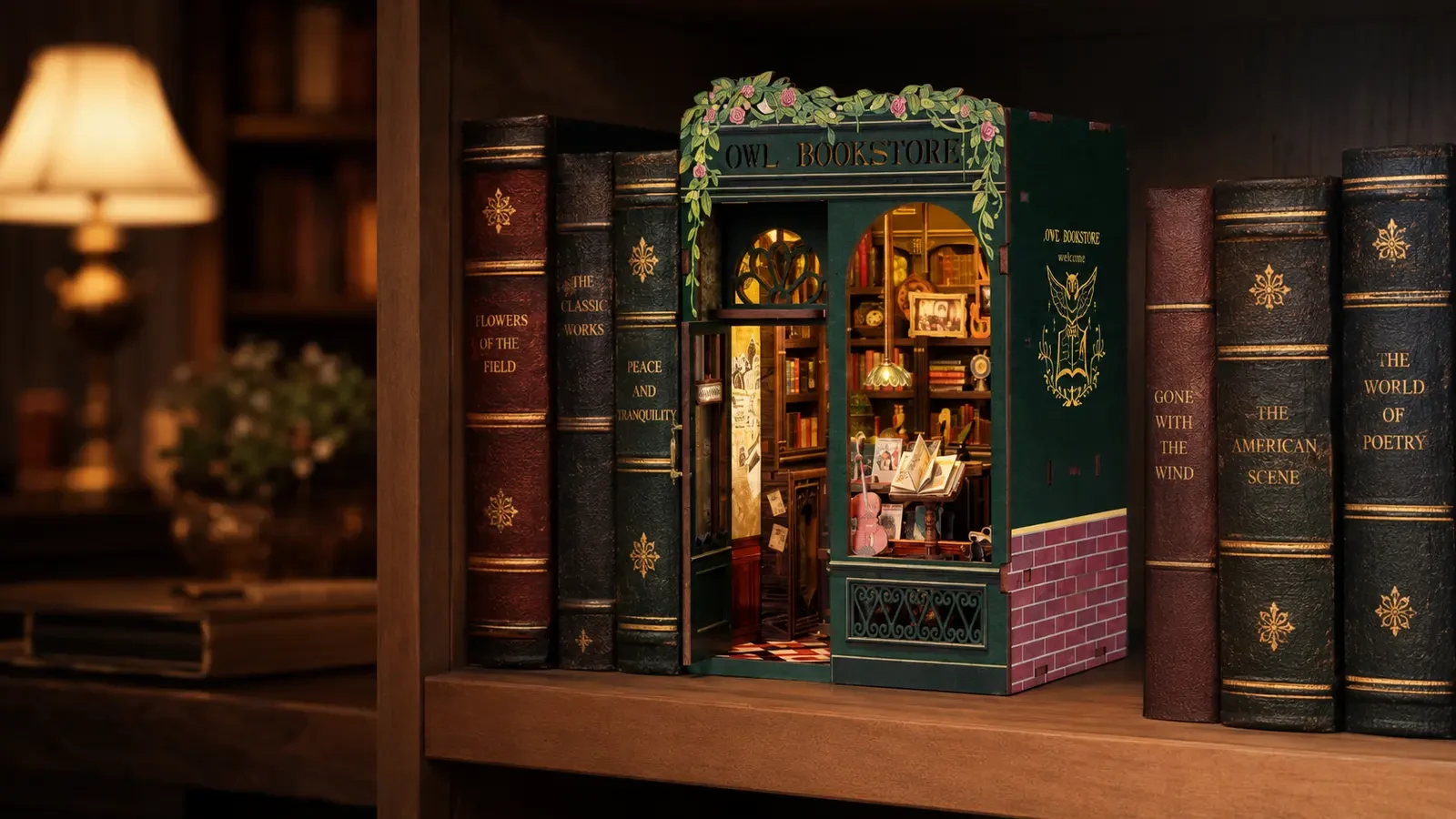 Owl Bookstore DIY Book Nook Kit glowing between classic books on a warm wooden bookshelf.